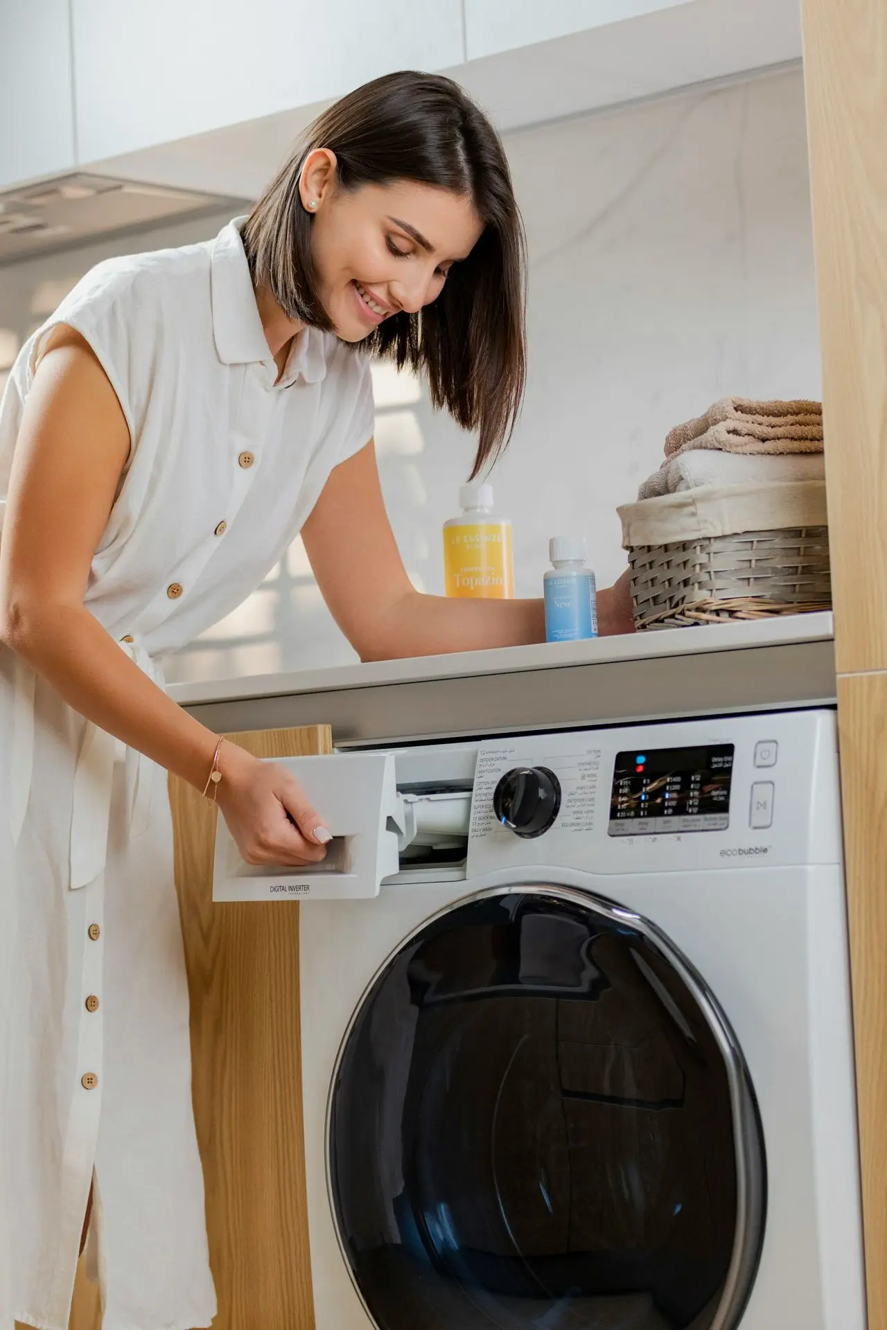 a woman is putting something in a washing machine